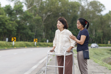 Fototapeta premium senior woman using a walker cross street