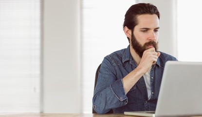 Hipster businessman working on his laptop