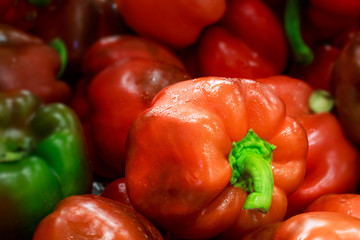 Red sweet pepper with blurred peppers on background