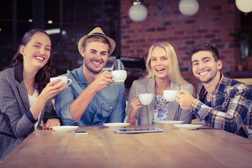 Smiling friends enjoying coffee together