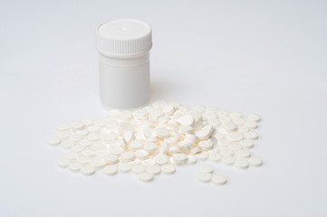 White pills lying near a white bottle