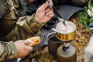 rangers are heated food on the fire and eat in the forest