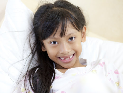 beautiful little girl grinning at the camera showing off her mis