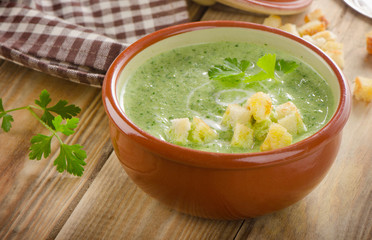 Creamy soup with  croutons on  wooden table.