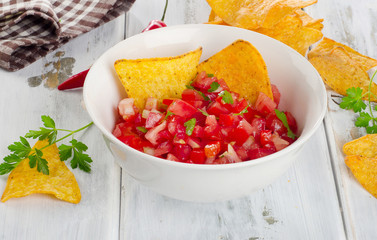 Bowl of  salsa dip with chips.