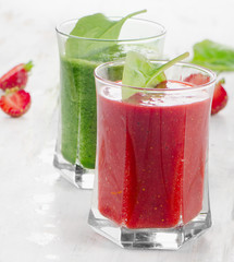 Spinach and strawberry smoothies in glasses.