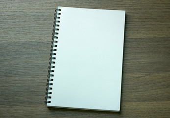 blank spiral notebook on dark wood background