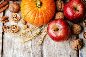 wood background with pumpkin, apples, wheat, honey and nuts
