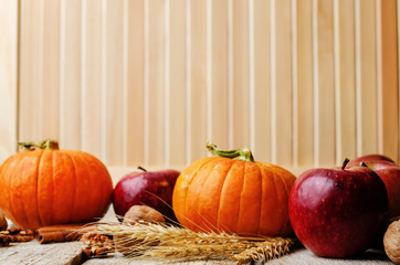 wood background with pumpkin, apples, wheat, honey and nuts