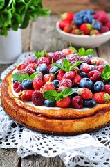 Cottage cheese casserole with fresh strawberries, blueberries, raspberries and mint and powdered sugar