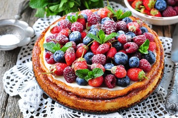 Cottage cheese casserole with fresh strawberries, blueberries, raspberries and mint and powdered sugar