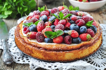 Cottage cheese casserole with fresh strawberries, blueberries, raspberries and mint and powdered sugar