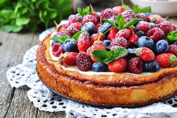 Cottage cheese casserole with fresh strawberries, blueberries, raspberries and mint and powdered sugar