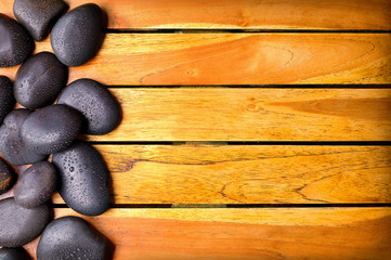 Stones with water drops on the left side on wooden