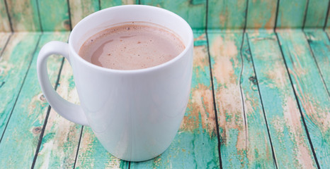 A mug of hot chocolate over wooden background