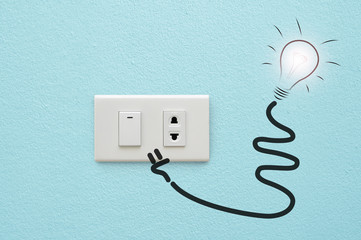 electric plug and lamp on blue wall background , idea concept