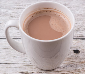 A mug of hot chocolate over wooden background