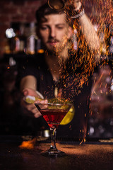The bartender makes a cocktail of fire.