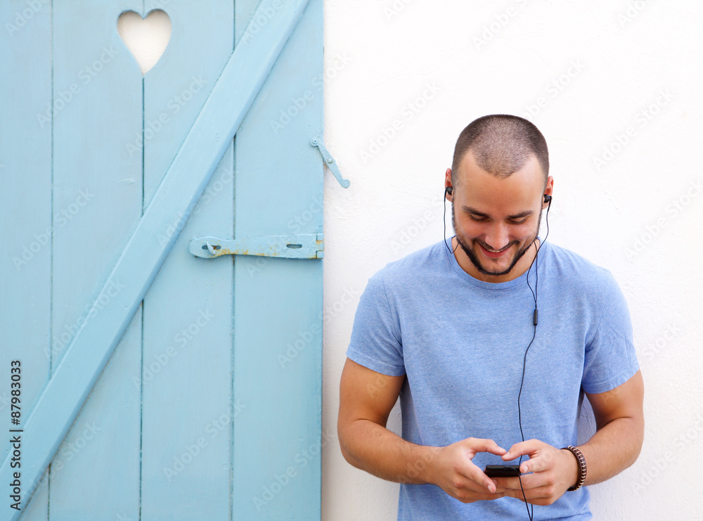 Wall mural happy guy listening to music on mobile phone