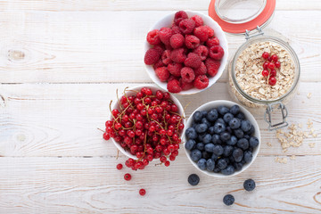 Breakfast - berries, fruit and muesli on white wooden