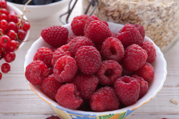 Breakfast - berries, fruit and muesli on white wooden