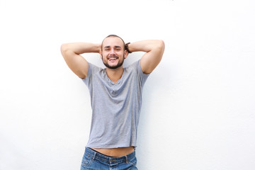 Happy young man smiling with hands behind his head