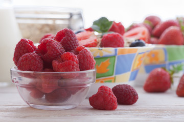 Breakfast - berries, fruit and muesli on white wooden