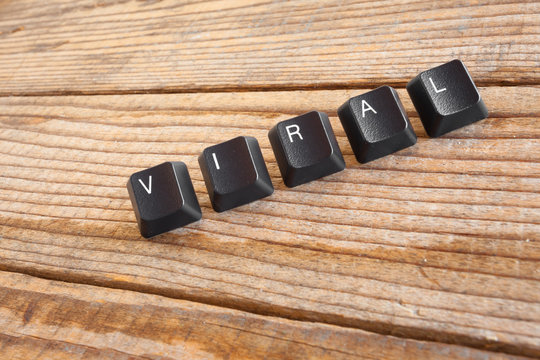 "VIRAL" wrote with keyboard keys on wooden background