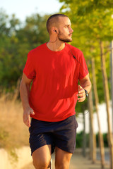 Young man running with earphones outside