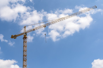 Industrial Construction Crane Against Blue Sky With Clouds