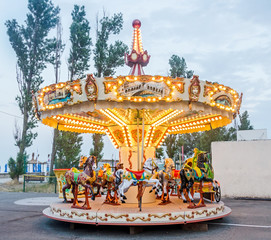 Vibrant colored carousel with lights and horses, close up, outdoor.