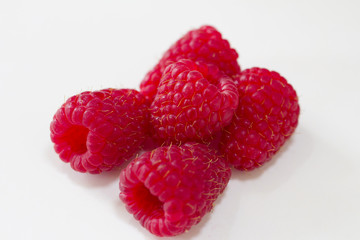 A cluster of fresh raspberries on a white background.