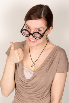 Junge Dame zeigt Grimassen mit dicker Brille // Ausdruck / albern 