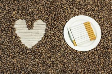 Coffee bean background with heart and croissant on white plate o