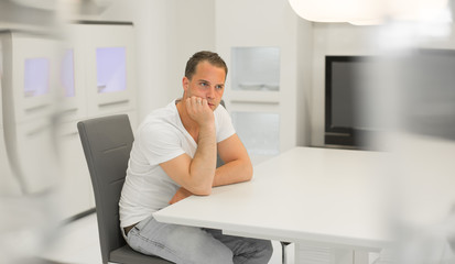 Junger Mann in weißem Wohnzimmer