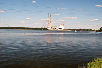 Fototapeta na wymiar river damm called Jezioro Rybnickie with sailboats and smokestakes on the background near Rybnik city