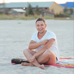 Fototapeta na wymiar Happy man resting on the beach in the evening