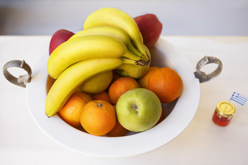 Fruit bowl/Fruit in deep plate, bananas, apples and oranges, honey
