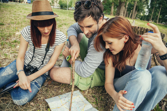 Group Of Tourists In Nature Using Map