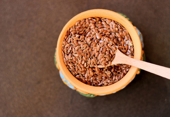 Flax seeds in a bowl with wooden spoon, selective focus