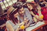 Three Young Tourists In Cafe