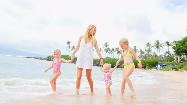 Mother walks with her daughters on the beach