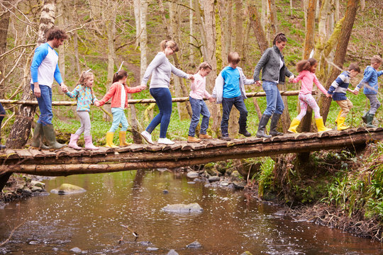 Adults With Children On Bridge At Outdoor Activity Centre