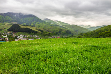 Fototapeta na wymiar village near meadow in mountains