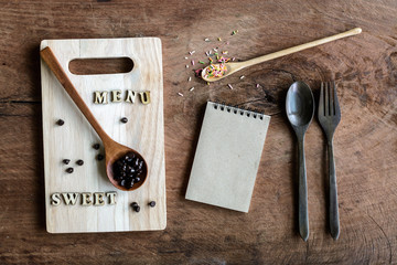 wooden spoon and fork with note on old wooden background