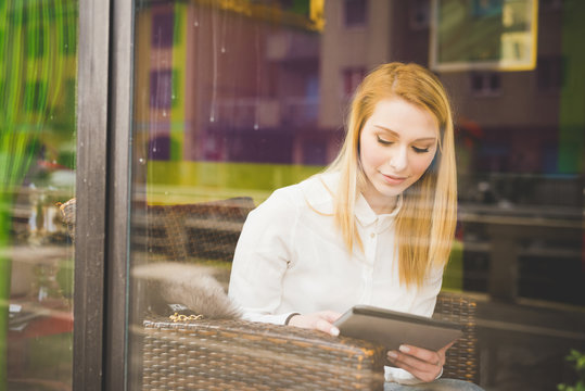Portrait of young woman using digital tablet in bar