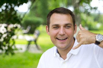 Happy brunette men making a call me gesture