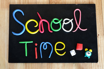"school time" text made from color clay on blackboard