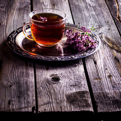 Tea with herbs on wooden background.