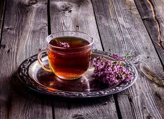 Tea with herbs on wooden background.